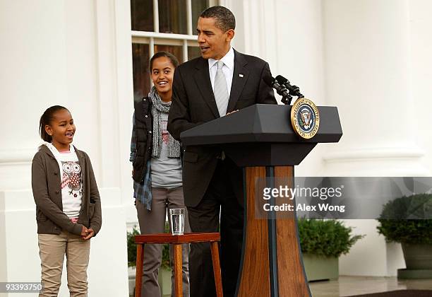 President Barack Obama speaks as his daughters Sasha and Malia listen during an event to pardon a turkey named "Courage" at the North Portico of the...
