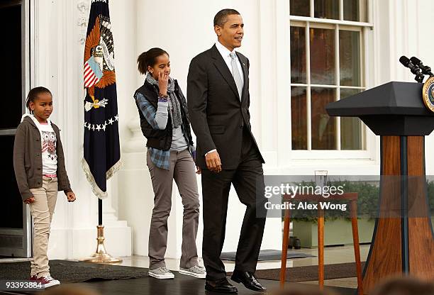 President Barack Obama, followed by his daughters Sasha and Malia , walks towards the podium during an event to pardon a turkey named "Courage" at...