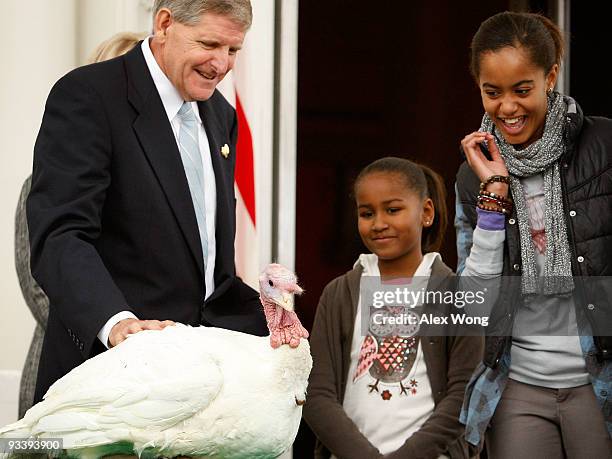 Daughters of U.S. President Barack Obama, Malia and Sasha , look at a turkey named "Courage" with Walter Pelletier , Chairman of the National Turkey...