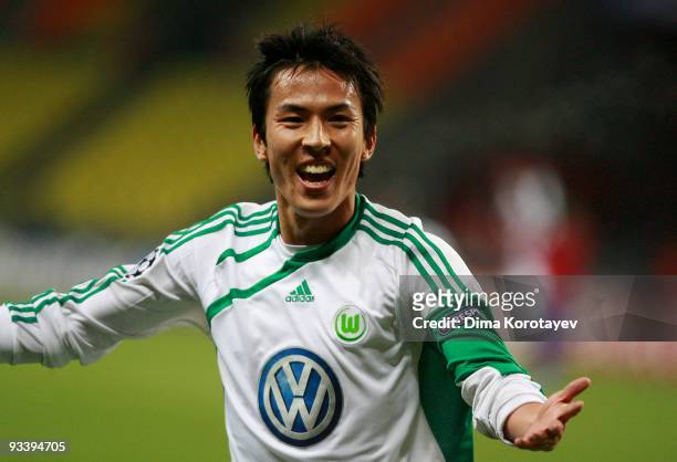 Makoto Hasebe of VfL Wolfsburg celebrates after his team mate Edin Dzeko scored the first goal during the UEFA Champions League group B match between...