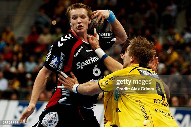 Oscar Carlen of Flensburg-Handewitt is challenged by Oliver Roggisch of Rhein-Neckar Loewen during the Toyota Handball Bundesliga match between...