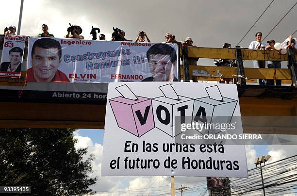 Photographers take pictures from a bridge of a march in favour of next November 29 elections, in Tegucigalpa on November 25, 2009. Campaigning ended...