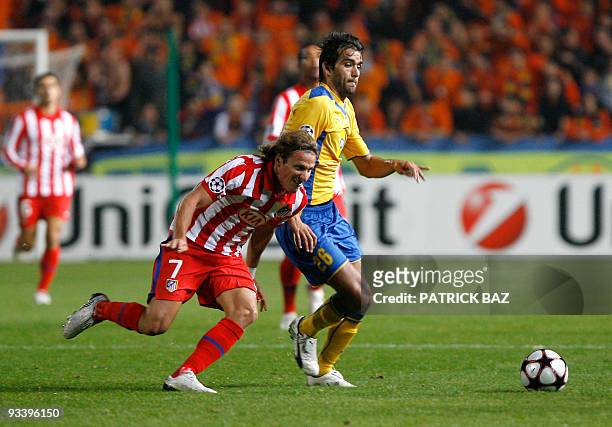 Atletico Madrid's Diego Forlan and Apoel Nicosia's Nuno Morais run for the ball during their UEFA Champions League group D football match at the GSP...