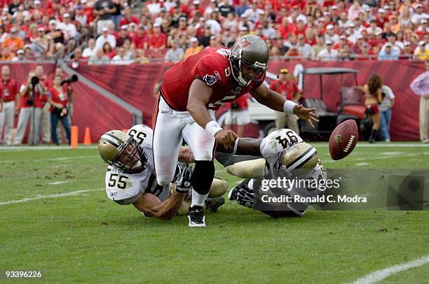 Quarterback Josh Freeman of the Tampa Bay Buccaneers is sacked by Scott Fujita and Charles Grant of the New Orleans Saints and fumbles the ball...