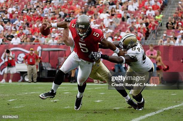 Quarterback Josh Freeman of the Tampa Bay Buccaneers scrambles and is chased by Scott Fujita and Charles Grant of the New Orleans Saints during a NFL...