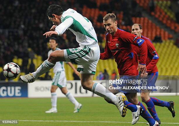 Marcel Schafer of Wolfsburg kicks a ball to score a goal as Aleksei Berezutski and Elvir Rahimic of CSKA Moscow run during the UEFA Champions League...