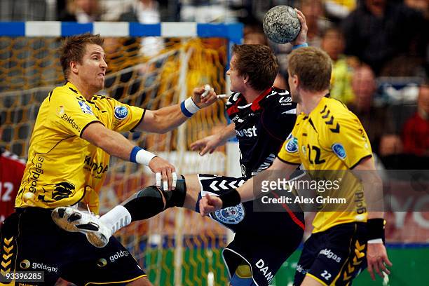 Oscar Carlen of Flensburg-Handewitt is challenged by Oliver Roggisch and Gudjon Valur Sigurdsson during the Toyota Handball Bundesliga match between...