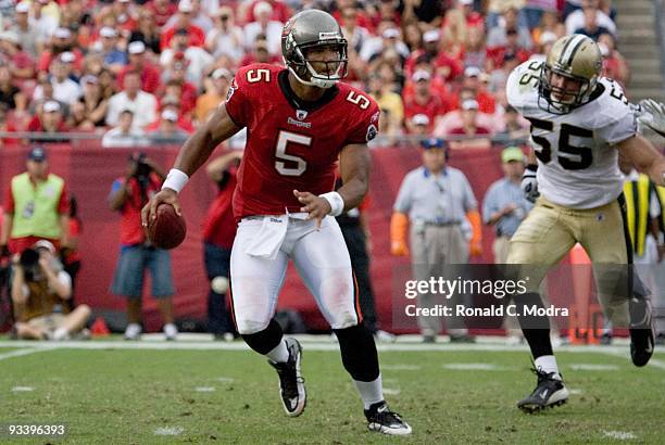 Quarterback Josh Freeman of the Tampa Bay Buccaneers scrambles and is chased by Scott Fujita of the New Orleans Saints during a NFL game on November...