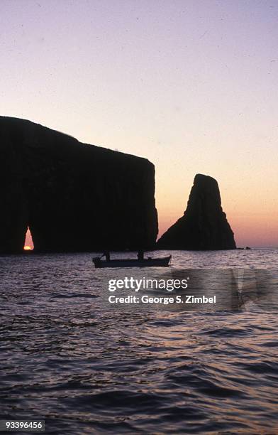 View of the sunset through the natural arch in Perce Rock, Gaspe Peninsula, Quebec, late twentieth century.