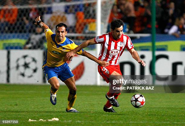 Apoel Nicosia's Savvas Poursaitides challenges Atletico Madrid's Jose Manuel Jurado during their UEFA Champions League group D football match at the...