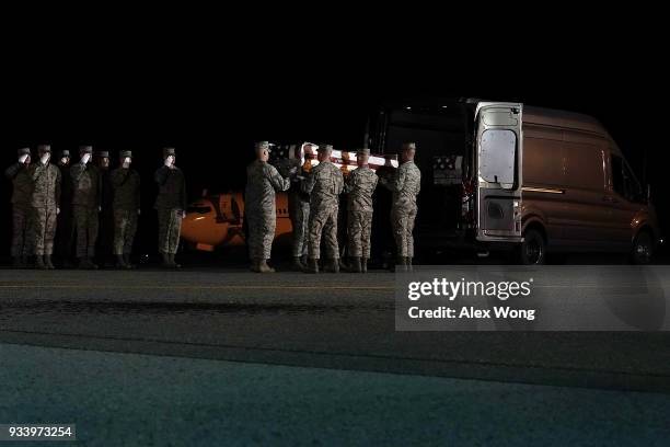 Members of a U.S. Air Force carry team move the flag-draped transfer case holding the remains of Air Force Master Sergeant Christopher J. Raguso of...