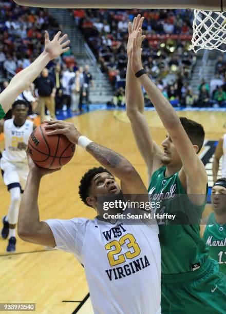 Esa Ahmad of the West Virginia Mountaineers shoots against Ajdin Penava of the Marshall Thundering Herd in the first half during the second round of...