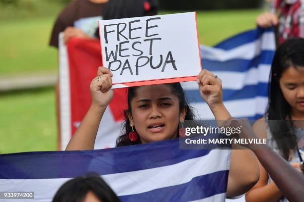 Small group of protesters hold signs reading "Free West Papua" outside the parliament in Wellington as Indonesia's President Joko Widodo visits the...