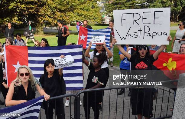 Small group of protesters hold signs reading "Free West Papua" outside the parliament in Wellington as Indonesia's President Joko Widodo visits the...