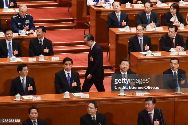 Newly elected State councilors Wang Yi walks by Chinese Premier Li Keqiang , Chinese President Xi Jinping and Chairman of the NPC Li Zhanshu as he...