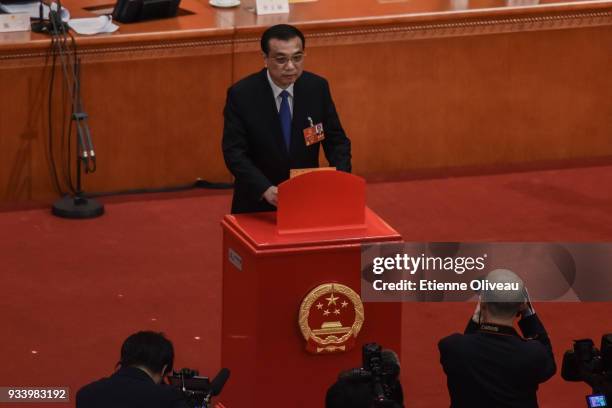 Chinese Premier Li Keqiang casts his vote during the seventh plenary session of the 13th National People's Congress at the Great Hall of the People...