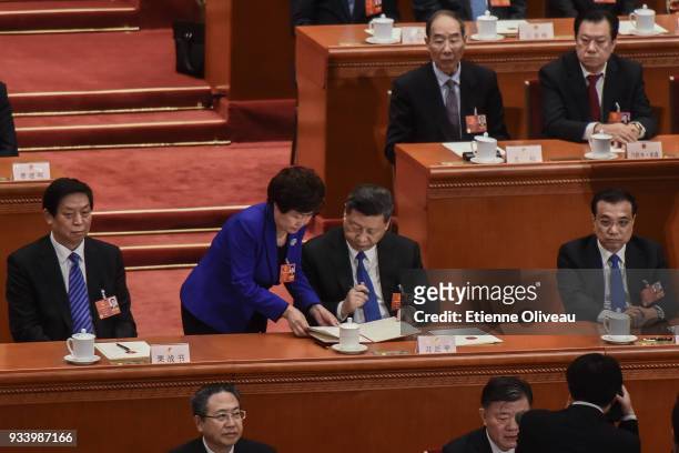 Chinese President Xi Jinping signs a document during the seventh plenary session of the 13th National People's Congress at the Great Hall of the...