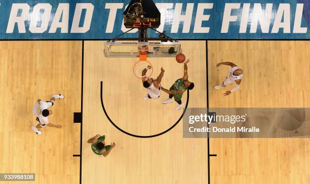 Burks of the Marshall Thundering Herd shoots against Sagaba Konate of the West Virginia Mountaineers in the second half during the second round of...