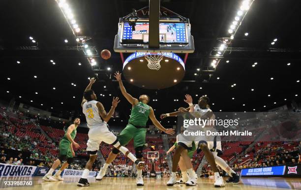 James Bolden of the West Virginia Mountaineers shoots against Phil Bledsoe of the Marshall Thundering Herd in the second half during the second round...