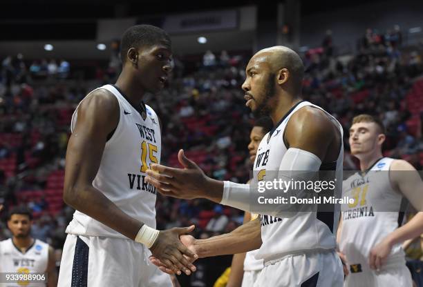 Lamont West and Jevon Carter of the West Virginia Mountaineers show comaraderie against the Marshall Thundering Herd in the second half during the...