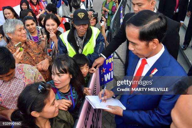 Indonesia's President Joko Widodo meets with supporters as he leaves the parliament after meeting New Zealand's prime minister in Wellington on March...