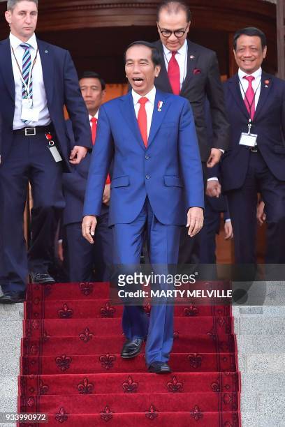 Indonesia's President Joko Widodo reacts as he sees supporters as he leaves the parliament after meeting New Zealand's prime minister in Wellington...