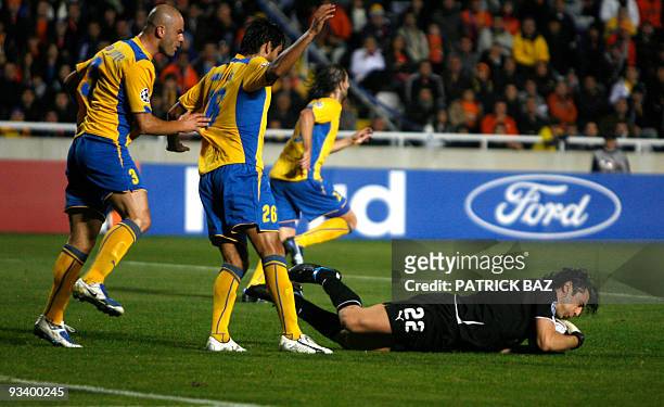 Apoel Nicosia's Paulo Jorge and Nuno Morais stand at defence as goalkeeper Dionisios Chiotis catches the ball during their UEFA Champions League...