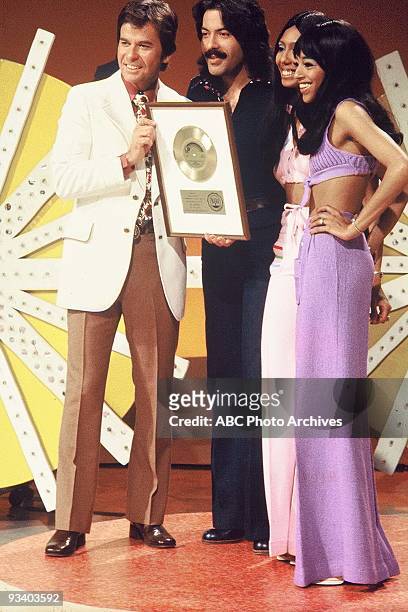 Host Dick Clark poses with Tony Orlando & Dawn and their gold record for "Tie a Yellow Ribbon "Round the Ole Oak Tree" on American Bandstand.,