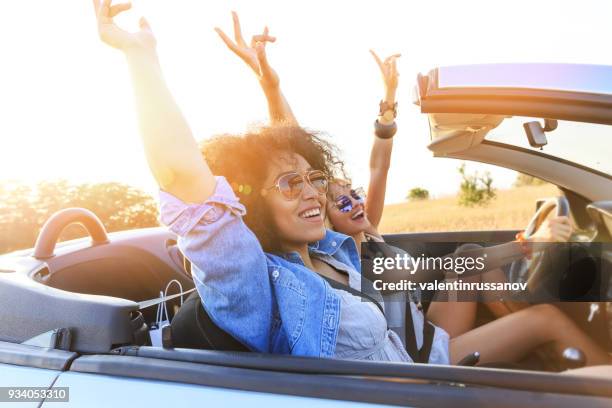 girlfriends having fun on road trip - car sunset arm stock pictures, royalty-free photos & images