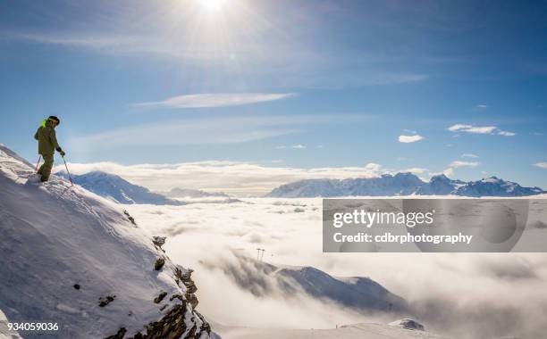 skifahrer, die auf einem felsen über den wolken - ski wear stock-fotos und bilder