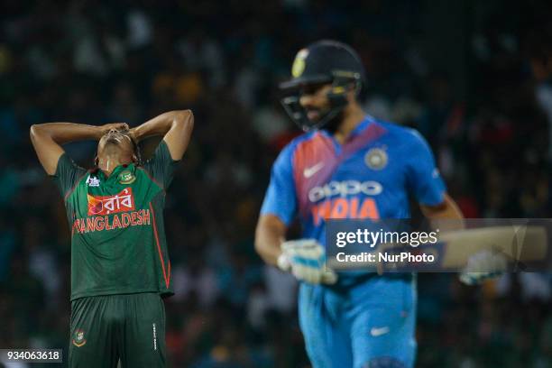 Bangladesh cricketer Rubel Hossain reatcs as Indian cricket captain Rohit Sharma plays a shot during the final Twenty-20 cricket match of NIDAHAS...
