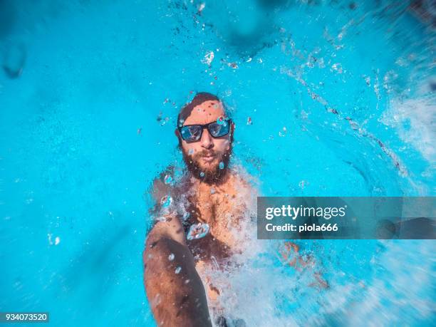 スイミング プールのユーモアで落ちながら男 selfie - water glasses ストックフォトと画像