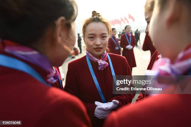 Hostesses discuss on Tiananmen Square after the seventh plenary session of the 13th National People's Congress at the Great Hall of the People on...