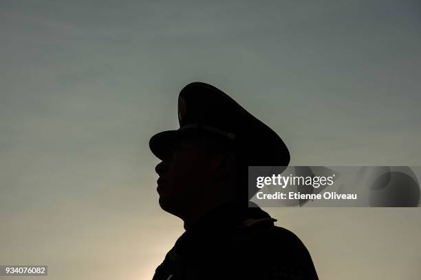 Paramilitary policeman stands guard on Tiananmen Square before the seventh plenary session of the 13th National People's Congress at the Great Hall...