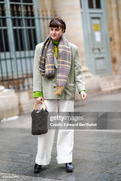 Guest wears a fringe yellow and grey prince-de-galles checkered scarf, a green shirt, a light grey jacket, white wide-leg cuffed pants, black square...