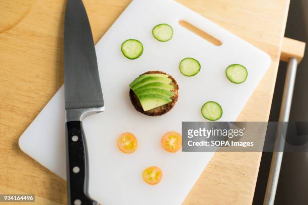 An avocado toast waiting to be decorated with slices of cucumber and tomato.