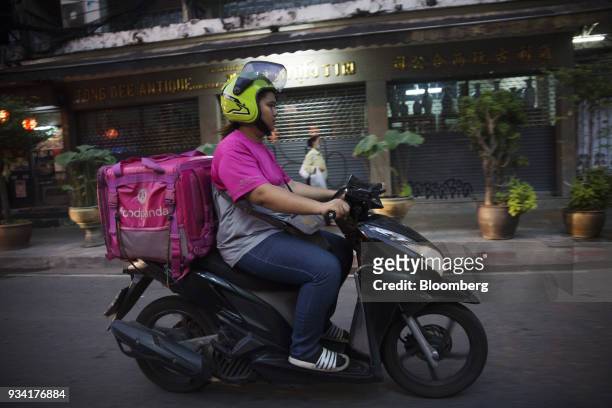 Courier for Foodpanda, a meal-delivery service operated by Delivery Hero AG, rides a motorcycle along a road in Bangkok, Thailand, on Friday, March...