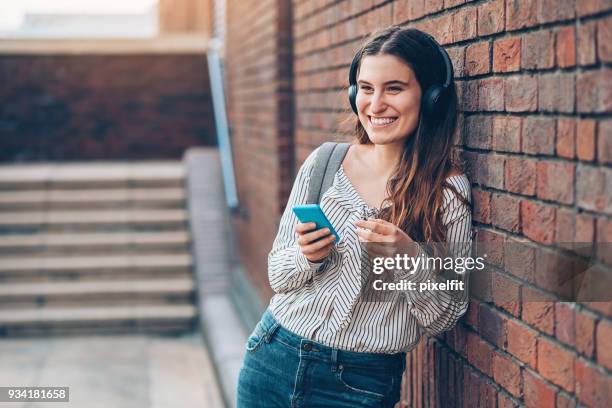 lachende meisje luisteren muziek van haar telefoon - 2017 common good forum stockfoto's en -beelden