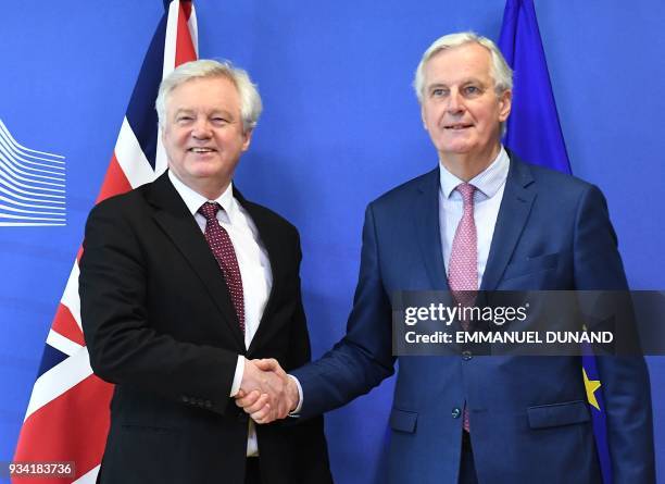 British Brexit minister David Davis and EU chief negotiator Michel Barnier shake hands as they meet at the European Commission in Brussels on March...