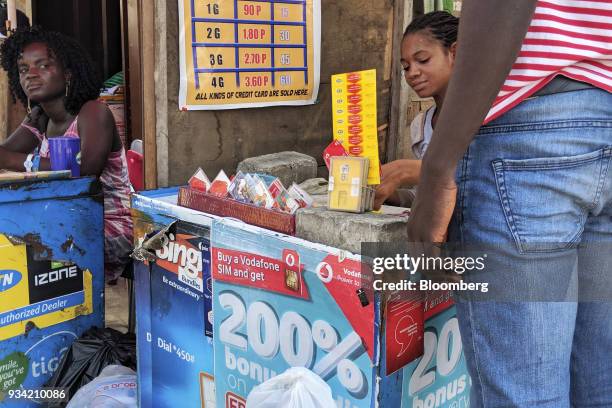 Street vendor sells pre-paid mobile phone credit scratch cards in Accra, Ghana, on Thursday, March 15, 2018. Ghana wants to shake up the way it...