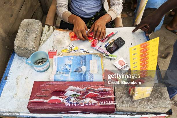 Street vendor sells pre-paid mobile phone credit scratch cards in Accra, Ghana, on Thursday, March 15, 2018. Ghana wants to shake up the way it...