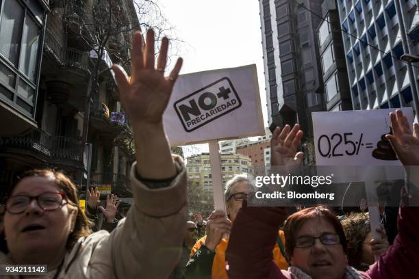 Protesters wave placards as they march along Roger de Lluria street during the 'Marea Pensionista' demonstration for pension reform in Barcelona,...