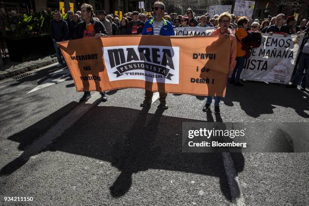 Protesters carry a banner along Roger de Lluria street during the 'Marea Pensionista' demonstration for pension reform in Barcelona, Spain, on...