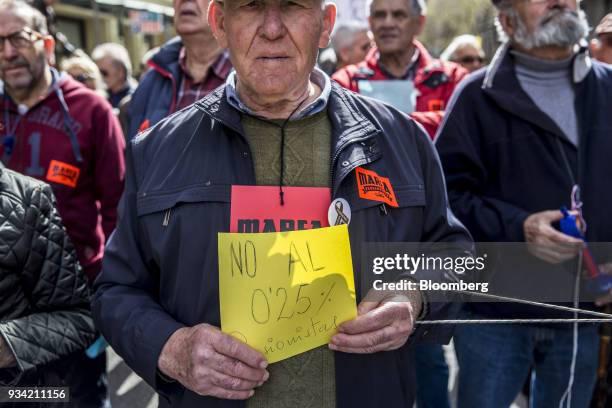 Protester carries a sign on Roger de Lluria street during the 'Marea Pensionista' demonstration for pension reform in Barcelona, Spain, on Saturday,...