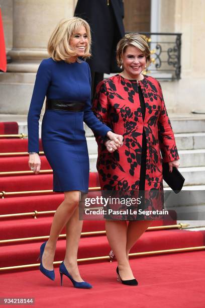 Brigitte Macron and Maria Teresa, Grand Duchess of Luxembourg smile as they walk in the courtyard of Elysee Palace on March 19, 2018 in Paris,...