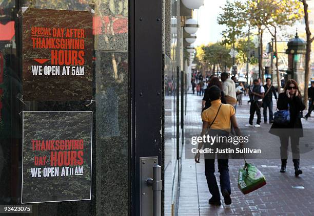 Pedestrians walk by an advertisement for Thanksgiving Day hours at an American Eagle store November 25, 2009 in San Francisco, California. As the...