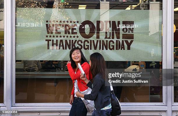 Pedestrians walk by an advertisement for Thanksgiving Day hours at an Old Navy store November 25, 2009 in San Francisco, California. As the economy...