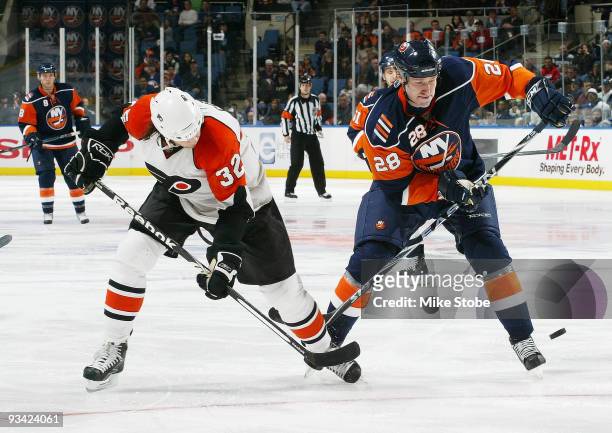 Tim Jackman of the New York Islanders battles for the puck against Riley Cote of the Philadelphia Flyers on November 25, 2009 at Nassau Coliseum in...