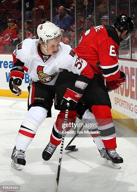 Brian Lee of the Ottawa Senators defends against Andy Greene of the New Jersey Devils at the Prudential Center on November 25, 2009 in Newark, New...