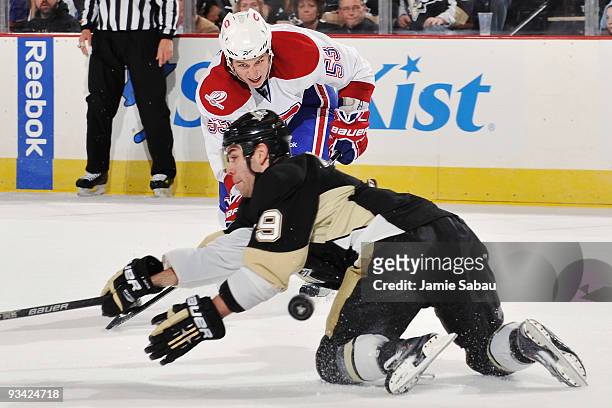 Ryan White of the Montreal Canadiens puts a pass under a diving Pascal Dupuis of the Pittsburgh Penguins on November 25, 2009 at Mellon Arena in...